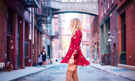 femme blonde portant une robe rouge avec des cuissarde camel dans une rue