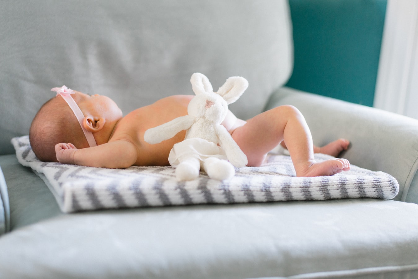 bébé entouré de ses cadeaux de naissance comme un doudou